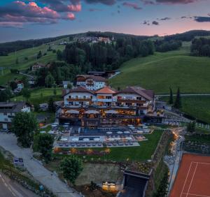 una vista aerea di un resort con un campo da tennis di Hotel Christoph a Valdaora