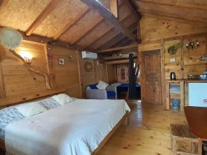 a bedroom with a bed in a room with wooden walls at Tiny houses Genacvale in Martvili