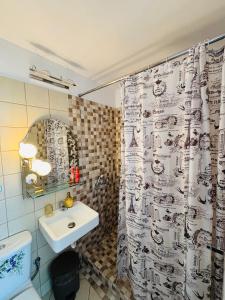 a bathroom with a sink and a shower curtain at Viva B&B in Anavyssos +65 photos