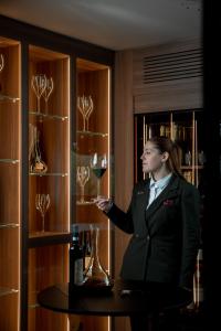 a woman in a suit holding a glass of wine at Hotel Livata Mountain Wellness in Subiaco +68 photos