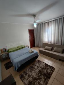 a bedroom with a bed and a couch at Hostel Bauru in Bauru