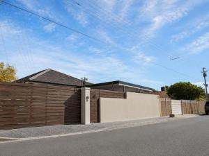 a house with a wooden fence and a gate at Pecan Tree Lodge in Cape Town