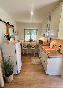 a kitchen with a white refrigerator and a table at Calma Apartments Gattendorf in Gattendorf