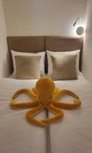 a stuffed octopus is laying on a bed at Calma Apartments Gattendorf in Gattendorf