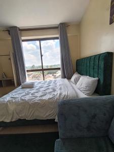 a bedroom with a bed and a window and a chair at Majestic studio in Rungiri