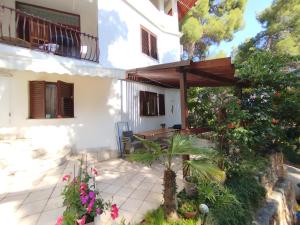 a patio of a house with an umbrella and flowers at Apartment Kordić in Sveta Nedelja