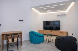 a living room with a table and a tv at Villa Manel in Georgioupoli