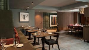 a restaurant with tables and chairs and a bar at Hotel Livata Mountain Wellness in Subiaco