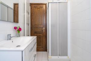 a bathroom with a sink and a wooden door at Casa Anna in Lierna