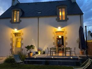 a house with a table and chairs in front of it at Gîte ty nina rosa in Penmarch