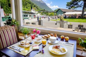 a table with breakfast food and a view of a street at Hotel Du Lac in Interlaken