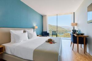 a bedroom with a large bed and a large window at Hotel Aquafalls in Caniçada +54 photos