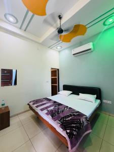a bedroom with a bed and a ceiling fan at Aasha Palace Khatu Shyam Ji in Khātu