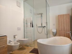 a bathroom with a tub and a toilet and a glass shower at Ferienwohnung EPIKUR in Payerbach