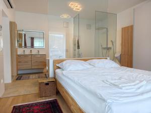a bedroom with a large white bed and a bathroom at Ferienwohnung EPIKUR in Payerbach
