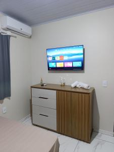 a room with a flat screen tv on a wall at Gk-Hospedagem in Foz do Iguaçu