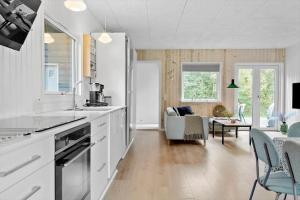 a kitchen with white cabinets and a living room at LF14143-Spottrup-Basaltvej-1 in Spottrup +13 photos