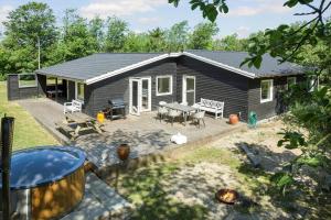 a tiny house with a patio and a table at LF14143-Spottrup-Basaltvej-1 in Spottrup