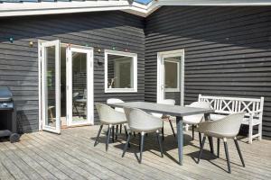 a patio with a table and chairs on a deck at LF14143-Spottrup-Basaltvej-1 in Spottrup