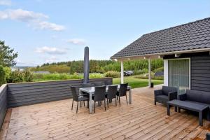 a wooden deck with a table and chairs on it at LF15028-Skals-Lynderup-Strand-6 in Skals