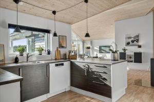 a kitchen with white and black cabinets and a sink at LF15028-Skals-Lynderup-Strand-6 in Skals