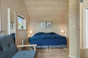 a bedroom with a bed in a room with wooden walls at LF15028-Skals-Lynderup-Strand-6 in Skals
