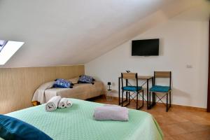 a room with two beds and a tv and a couch at Centro mare residence affitta alloggi in Porto Torres