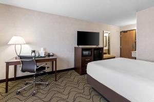 a hotel room with a bed and a desk and a chair at Days Inn by Wyndham Columbia Mall in Grand Forks