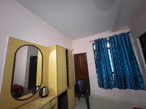 a room with a mirror and a dresser at Dmello guesthouse in Palolem
