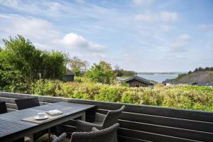 a table and chairs on a deck with a view of the water at LF15023-Skals-Lynderup-Strand-2 in Skals