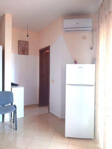 a room with a white refrigerator and a door at Appartamento lungomare Bianca in Vlorë