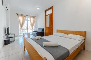 a bedroom with a bed with a chair and a desk at Andreas Beachfront Hostel in Larnaca