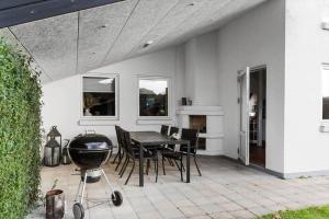 a patio with a grill and a table and chairs at LF13170-Nykobing-mors-Havevej-22 in Nykøbing Mors