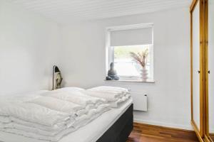 a white bedroom with a large bed with a window at LF13170-Nykobing-mors-Havevej-22 in Nykøbing Mors