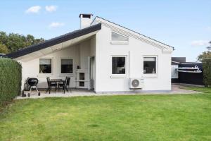 a white house with a table and chairs in a yard at LF13170-Nykobing-mors-Havevej-22 in Nykøbing Mors