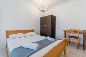 a bedroom with a bed with a desk and a chair at Andreas Beachfront Hostel in Larnaca