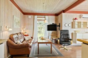 a living room with a leather couch and a chair at LF18110-Veslos-Agerovej-13 in Vesløs