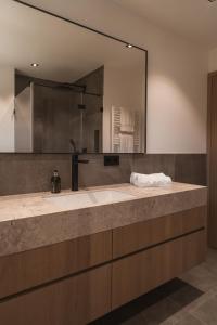 a bathroom with a sink and a large mirror at Egerner Chalet in Rottach-Egern +26 photos