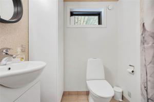 a white bathroom with a toilet and a sink at LF14102-Roslev-Eskovvej-102 in Roslev +12 photos