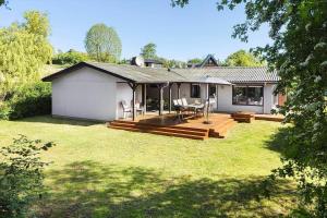 a house with a deck and a table and chairs at LF14102-Roslev-Eskovvej-102 in Roslev