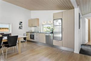 a kitchen with a table and a refrigerator and cabinets at LF530-Vestervig-Hannesvej-30 in Vestervig +12 photos