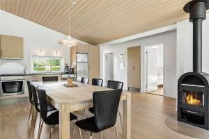 a kitchen and dining room with a table and a fireplace at LF530-Vestervig-Hannesvej-30 in Vestervig