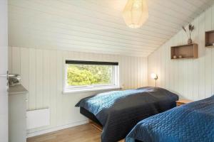 a bedroom with two beds and a window at 393-Harboore-Fourmivej-10 in Harboør