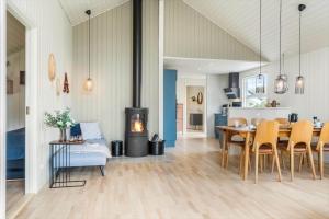 a living room with a dining table and a fireplace at 393-Harboore-Fourmivej-10 in Harboør