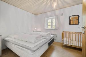 a white bedroom with a bed and a crib at 0007-Romo-Juvrevej-37 in Høm