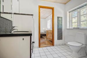 a bathroom with a toilet and a sink and a mirror at 0007-Romo-Juvrevej-37 in Høm +18 photos