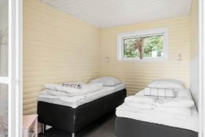 two beds in a room with a window at LF15319-Hojslev-Jelsevej-319 in Højslev
