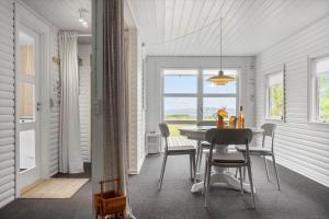 a dining room with a table and chairs and a window at LF15319-Hojslev-Jelsevej-319 in Højslev +16 photos