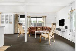 a living room with a couch and a table and chairs at LF15319-Hojslev-Jelsevej-319 in Højslev