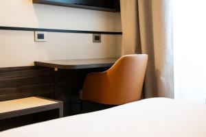 a room with a desk and a chair and a table at Hotel Regina in Milan
